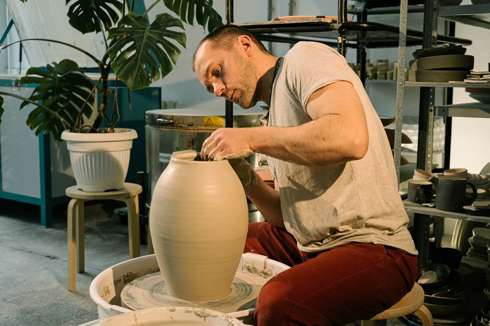 The potter trimming the vase, turned away to his work.